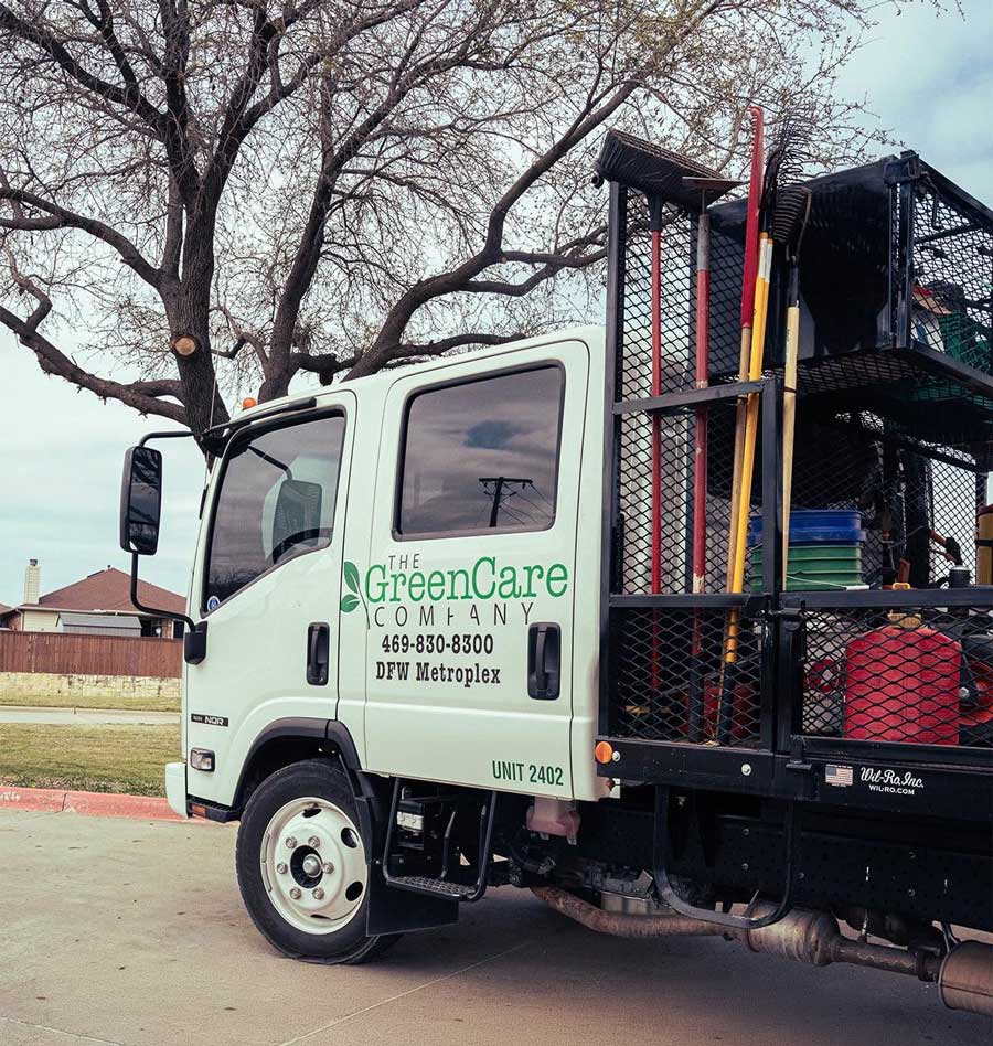 GreenCare company truck loaded with tools for residential lawn care service